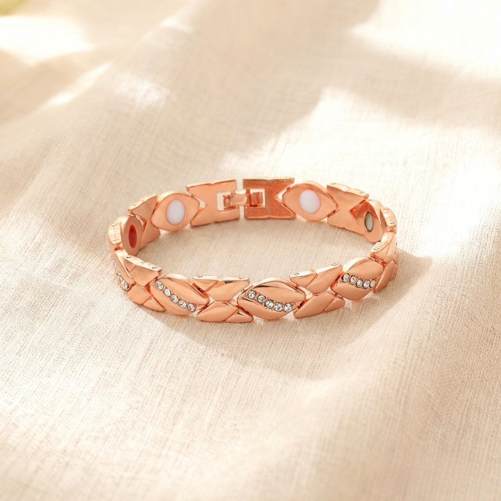 Rose gold bracelet with braided design and embedded stones on a beige fabric background